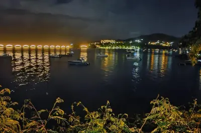 a group of boats on the water at night at Indy's Best Bay FrontView in Samana. in Santa Bárbara de Samaná