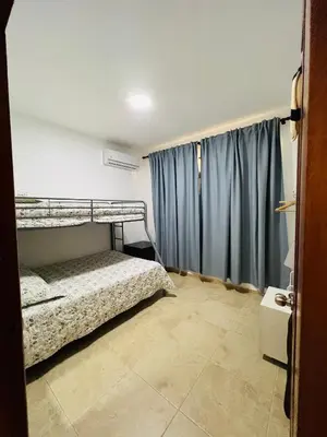 a bedroom with a bunk bed and blue curtains at Lovely Beachfront 2 bedrooms condo with 2 pools in Las Terrenas