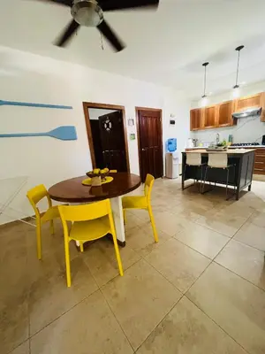 a kitchen and dining room with a table and yellow chairs at Lovely Beachfront 2 bedrooms condo with 2 pools in Las Terrenas