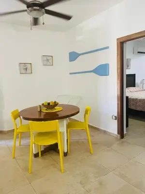 a dining room with a table and yellow chairs at Lovely Beachfront 2 bedrooms condo with 2 pools in Las Terrenas