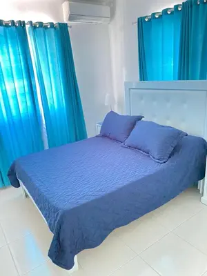 a bedroom with a blue bed with blue curtains at Ria Hotel in San Felipe de Puerto Plata