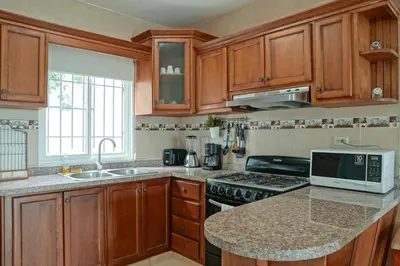 a kitchen with wooden cabinets and a counter top at Ria Hotel in San Felipe de Puerto Plata