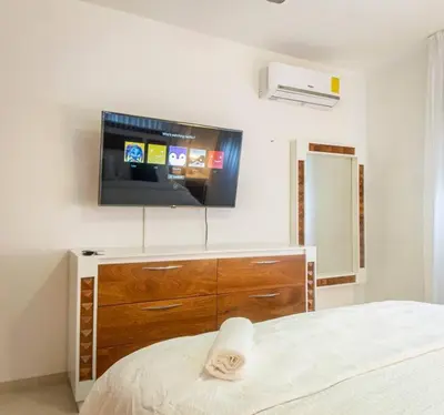 a bedroom with a flat screen tv on the wall at Modern apartment in Santiago de Los caballeros in Santiago de los Caballeros