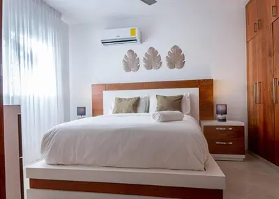 a bedroom with a large bed with a white bedspread at Modern apartment in Santiago de Los caballeros in Santiago de los Caballeros