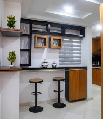 a kitchen with two bar stools and a counter at Modern apartment in Santiago de Los caballeros in Santiago de los Caballeros