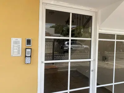 a sliding glass door with a car in the reflection at Beautiful Penthouse in La Vega, RD in Concepción de La Vega