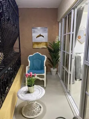 a hallway with a blue chair and a table at Sweet Home in Santiago de los Caballeros