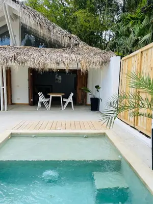 a house with a pool and a table and a thatch roof at Villa Tortuga, Guest house Private bungalow, private pool in Las Terrenas