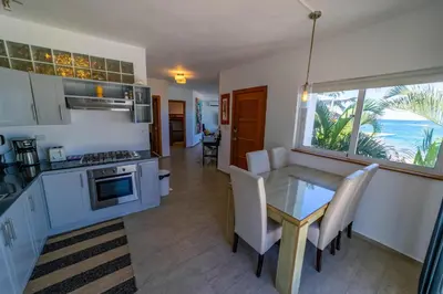 a kitchen and dining room with a table and a view of the ocean at Panoramic Views Two Decks 1st Row Ocean Kite Beach in Cabarete