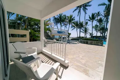 a porch with chairs and a view of the beach at Kite Beach Oceanfront 1st Row Two Bedrooms and patio in Cabarete