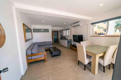 a kitchen and living room with a table and a couch at Kite Beach Oceanfront 1st Row Two Bedrooms and patio in Cabarete