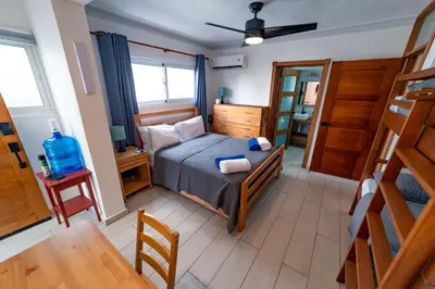 a small bedroom with a bed and a table at Studio Beachfront Kite Beach in Cabarete