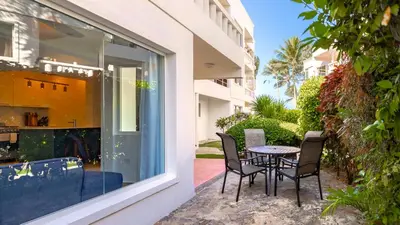 a patio with a table and chairs next to a building at Kite Beach Oceanfront Two Bedroom Patio and Garden in Cabarete