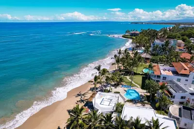an aerial view of a beach with palm trees and buildings at Kite Beach Oceanfront Two Bedroom Patio and Garden in Cabarete