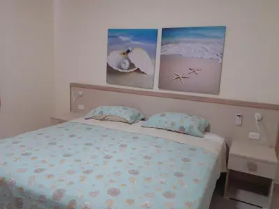 a bedroom with a bed and two pictures on the wall at CoralK Apartments Sosúa in Sosúa