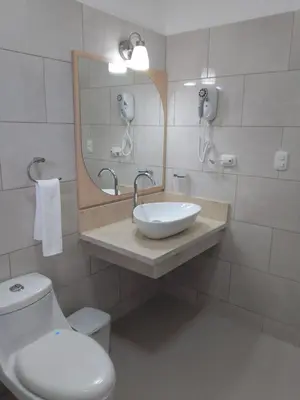 a bathroom with a toilet and a sink and a mirror at CoralK Apartments Sosúa in Sosúa
