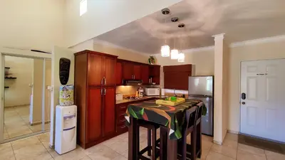 a kitchen with a table and a refrigerator at Ocean Dream Art Deco Studio w/balcony in Cabarete