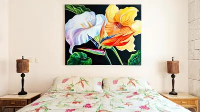 a painting of flowers on a wall above a bed at Ocean Dream 2bdr/2bth Ground floor in Cabarete