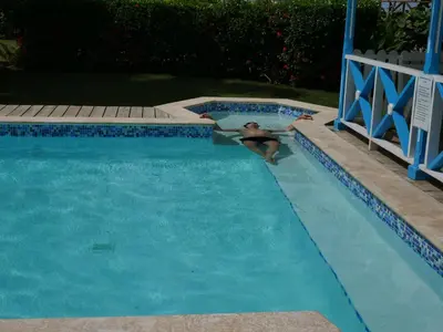 a man swimming in a swimming pool at Costarena Beach Hotel in Las Terrenas