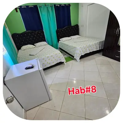 two beds in a room with a mirror at Wilkan Hotel in Las Terrenas