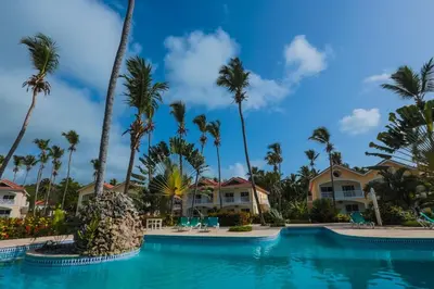a pool at a resort with palm trees and houses at The Cove Apartment Second Floor 5C in Santa Bárbara de Samaná