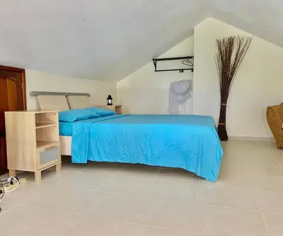 a bedroom with a bed with a blue bedspread at The Cove Apartment Second Floor 5C in Santa Bárbara de Samaná