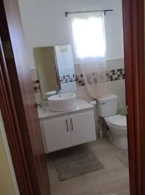 a bathroom with a sink and a toilet and a window at Cabrera Family Villa in Cabrera
