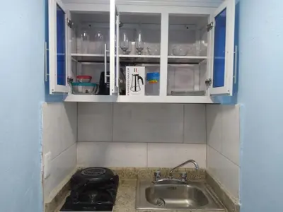 a kitchen with white cabinets and a sink at Paulino in Santiago de los Caballeros
