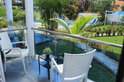 a balcony with two chairs and a table and plants at Cozy and Central apartment 1br-1ba with Pool in Sosúa