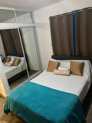 a bedroom with a bed with a large mirror at Escapade tropicale in Santiago de los Caballeros