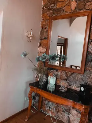 a wooden table with a mirror on a stone wall at Villa paloma in Constanza