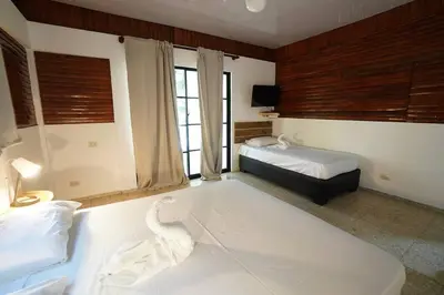 a bedroom with two beds and a tub in it at Room #27 at Waterfront Playa Alicia in Sosúa