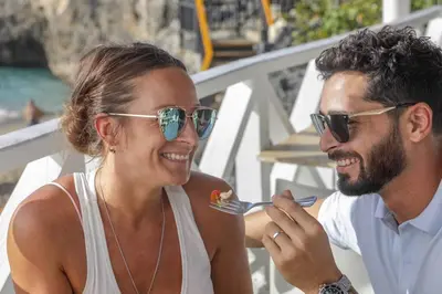 a man and a woman eating food with a fork at Room #26 at Waterfront Playa Alicia in Sosúa