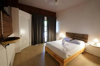 a bedroom with a bed and two lamps and a window at Room #26 at Waterfront Playa Alicia in Sosúa