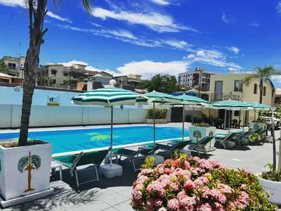 a swimming pool with umbrellas and lounge chairs and a pool at LA VlTA E' BELLA in Los Mameyes