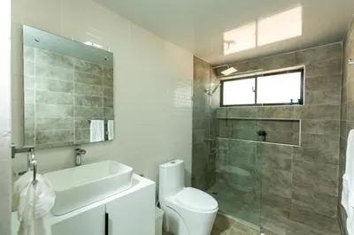 a bathroom with a toilet and a sink and a shower at Skylight Suites Hotel in San Felipe de Puerto Plata