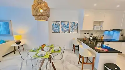 a kitchen and living room with a table and chairs at Hermoso Apartamento Cana Rock Star Acceso Directo a la Piscina C-105, C-106, B-102 y B-104 in Punta Cana