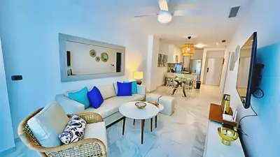 a living room with a couch and a table at Hermoso Apartamento Cana Rock Star Acceso Directo a la Piscina C-105, C-106, B-102 y B-104 in Punta Cana
