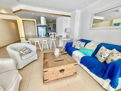 a living room with a blue couch and a table at 707 Marbella 2bedroom Beachfrom Apt in San Pedro de Macorís