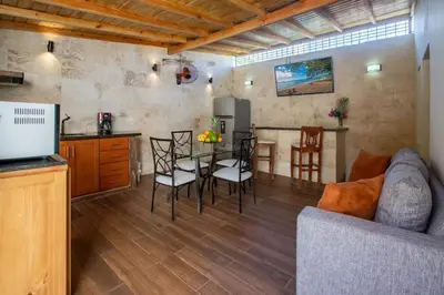 a kitchen and a living room with a table and chairs at Central Area Bedroom With Common Kitchen, living room in Sosúa