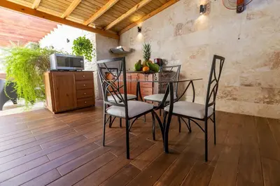 a dining room with a table and chairs on a wooden floor at Nice 1br-1bt With Common Picuzzi in Sosúa
