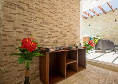 a wooden desk with a vase with a red flower at Cozy 1bd with common Jacuzzi in Sosúa