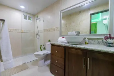 a bathroom with a sink and a toilet and a shower at Cozy 1bd with common Jacuzzi in Sosúa