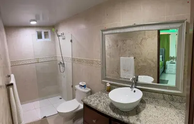 a bathroom with a sink and a toilet and a shower at Cozy 1bd with common Jacuzzi in Sosúa
