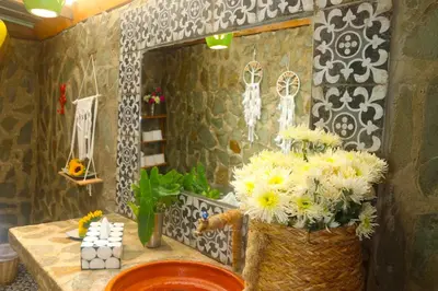 a bathroom with a vase of flowers on a table at EL GALLO ECOLODGE in San Felipe de Puerto Plata