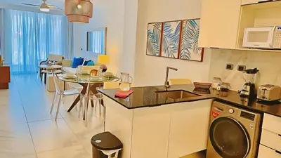 a kitchen and living room with a table and chairs at Cana Rock Star, Vista al campo de golf y Piscina C-303, B-400, B-506 y B-502 - Desayuno in Punta Cana