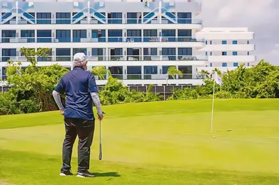 a man is standing on a golf course at Cana Rock Star, Vista al campo de golf y Piscina C-303, B-400, B-506 y B-502 - Desayuno in Punta Cana