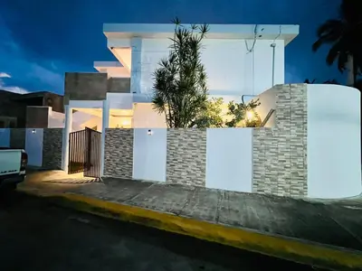 a house with a fence and a palm tree in it at Noe Hotel ,1 Bed Room 2 Near to the beach in Punta Cana