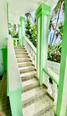 a staircase in a house with a green and white railing at Hospedaje Villa Valencia en Los Patos in Los Patos