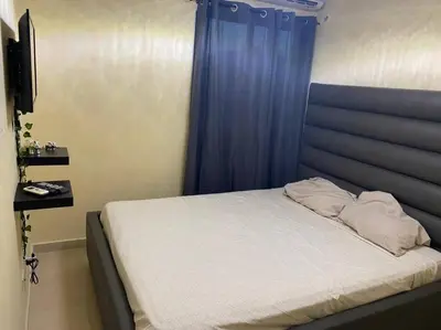 a bedroom with a bed with a blue curtain at Lesnah Apartamento, Jacobo Majluta in Los Casabes